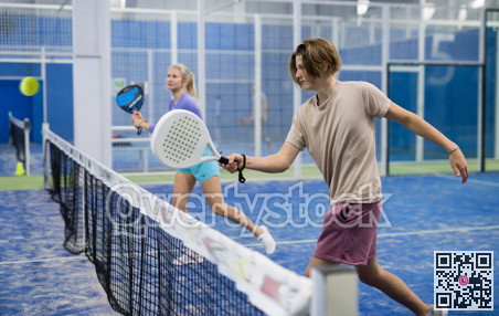 Guy playing paddle tennis on padel court indoors