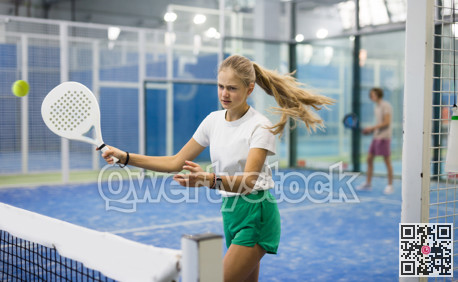 Teenage girl playing padel game on court