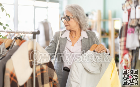 Family clothing store, senior woman customer chooses jacket or coat