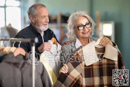 Family clothing store, senior couple customer chooses jacket or coat