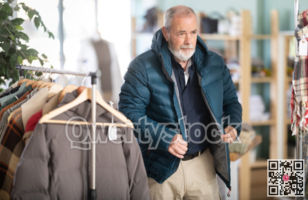 Elderly man trying on a down jacket