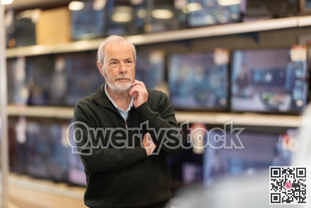 man stands near the TV sets in a store