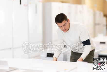 Guy choose modern washing machine or dishwasher at supermarket