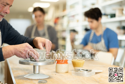 Close-up of elderly man's hands sculpting ceramic piece