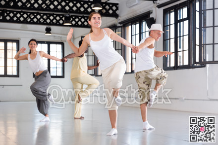 Positive people dancing twist together at dance studio