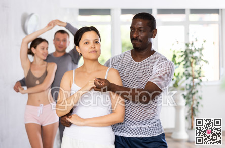 Smiling woman enjoying dance with African american male partner in dancing class