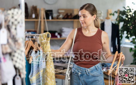 Adult woman choosing summer clothes in store