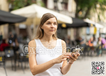 Female pedestrian with phone in summer European capital