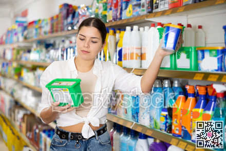 in shop woman carefully chooses laundry capsules