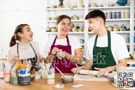 Joyous young man and women sculpting handmade cups
