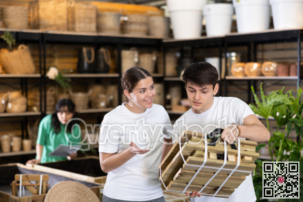 guy and girl choose folding wooden furniture for country house in store