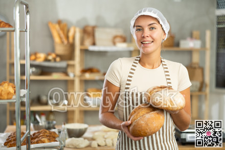 Young woman are standing in kitchen with finished products two loaves of rye bread
