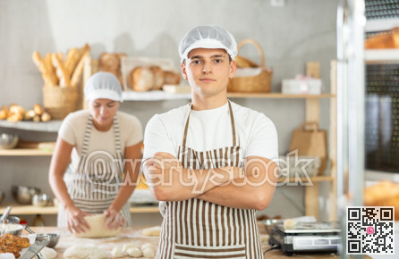 Portrait of male baker in an apron in interior of private bakery