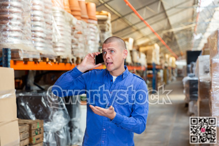 Fulfillment center worker talking on phone in warehouse