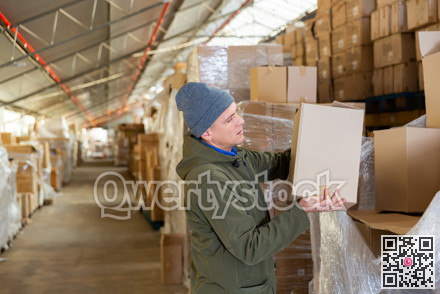 Warehouse worker carrying pasteboard box