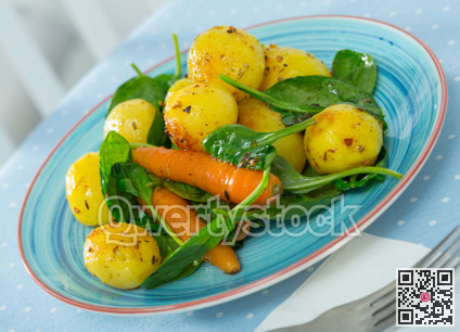Delicious cooked fried new potatoes with spinach served at plate