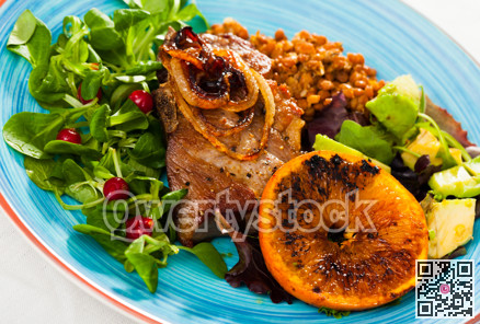 Baked pork shank with grilled orange, lentils, avocado, cornsalad
