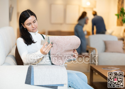 Woman deciding on material for couch in furniture shop