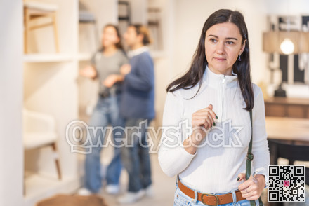 Female shopper looking around in bedroom department of furniture store