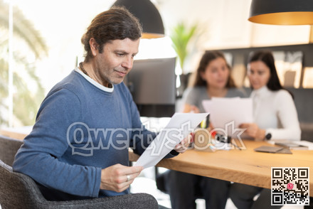 Adult man carefully reads the terms of the contract in furniture store