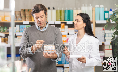 Man chooses packages with pills against the background of pharmacist