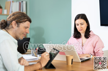 Male and female colleagues working with laptops and tablets