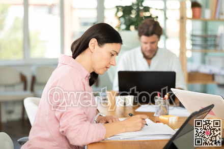 Middle-aged woman working with papers in modern office