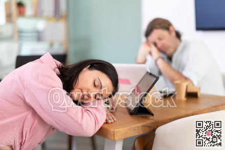 Middle-aged woman sleeping at the table after a long workday