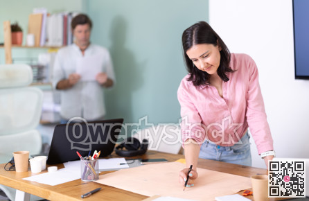 Adult man reviewing document, woman looks construction plan