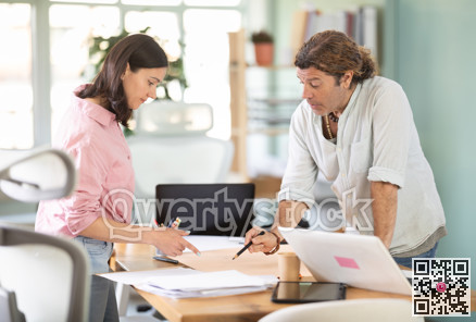 Adult man and woman colleagues discussing building plan in office