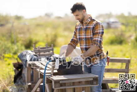 Young man filling bucket with water for field irrigation