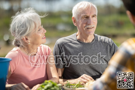 Happy family of farmers sits at table and discusses current affairs