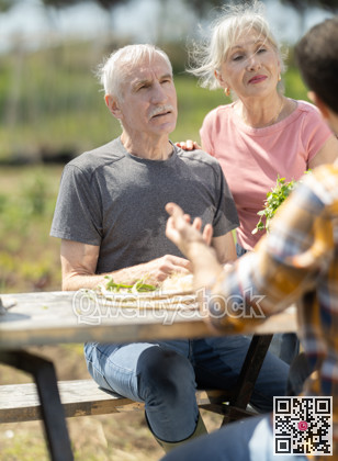 Happy family of farmers sits at table and discusses current affairs