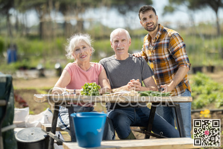 Happy family of farmers sits at table and discusses current affairs