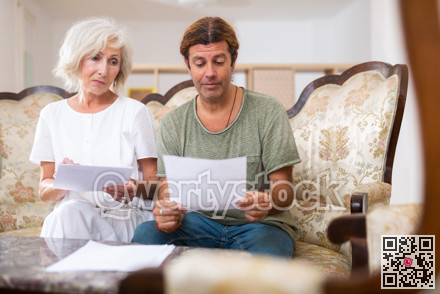 Helpful man helping elderly woman to sign documents