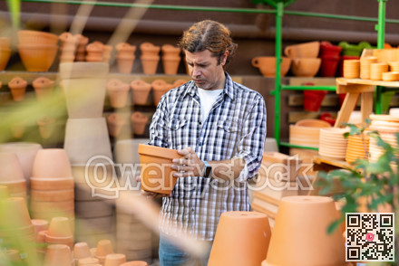 Interested amateur gardener looking for flowerpots at garden market