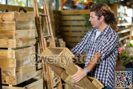 Attentive man choosing wooden pallets in garden store