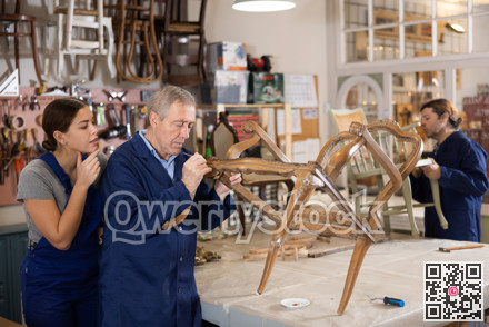 Senior man restorer spackling antique chair surface getting piece of furniture ready for further coloring