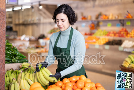 Woman shop seller puts banana goods on display case