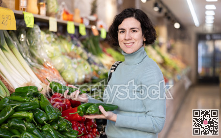 Woman choosing green peppers in the store