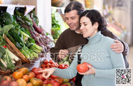 Husband and wife choose ripe tomatoes