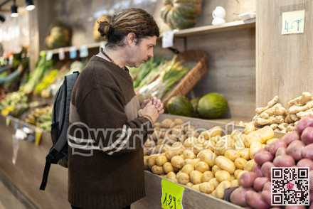 Grocery shopping - male shopper choosing vegetables on supermarket counter