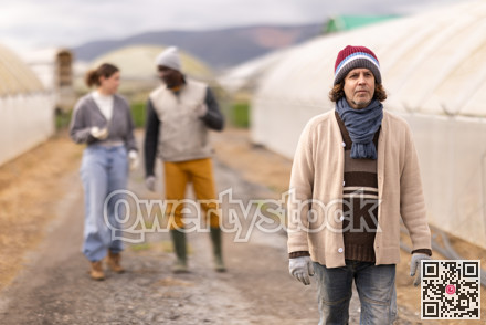 Adult male farmer with team at greenhouses
