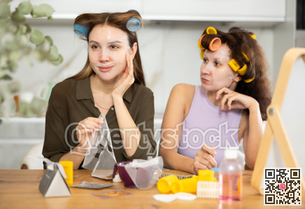 Two adult besties applying facial mask at home together
