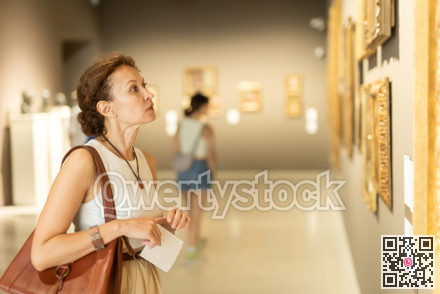 Woman looks at hall of paintings and sculptures