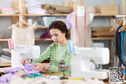 Woman tailor at work in cloth design shop