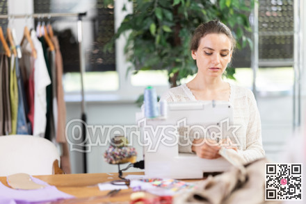 Woman tailor at work in cloth design shop