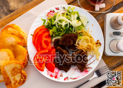Turkish kofte, grilled veal meatballs with vegetables and bread