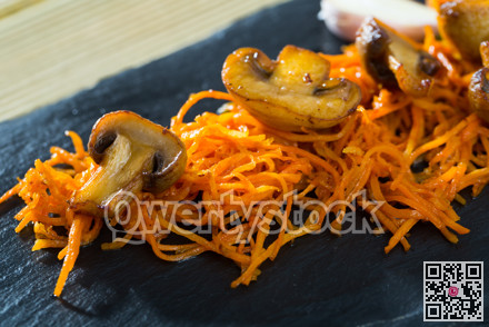Slate of freshly fried mushrooms with carrot