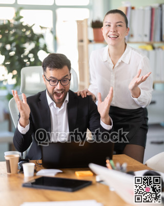 Man and a woman work in an office and are emotionally joy about the success in a new project